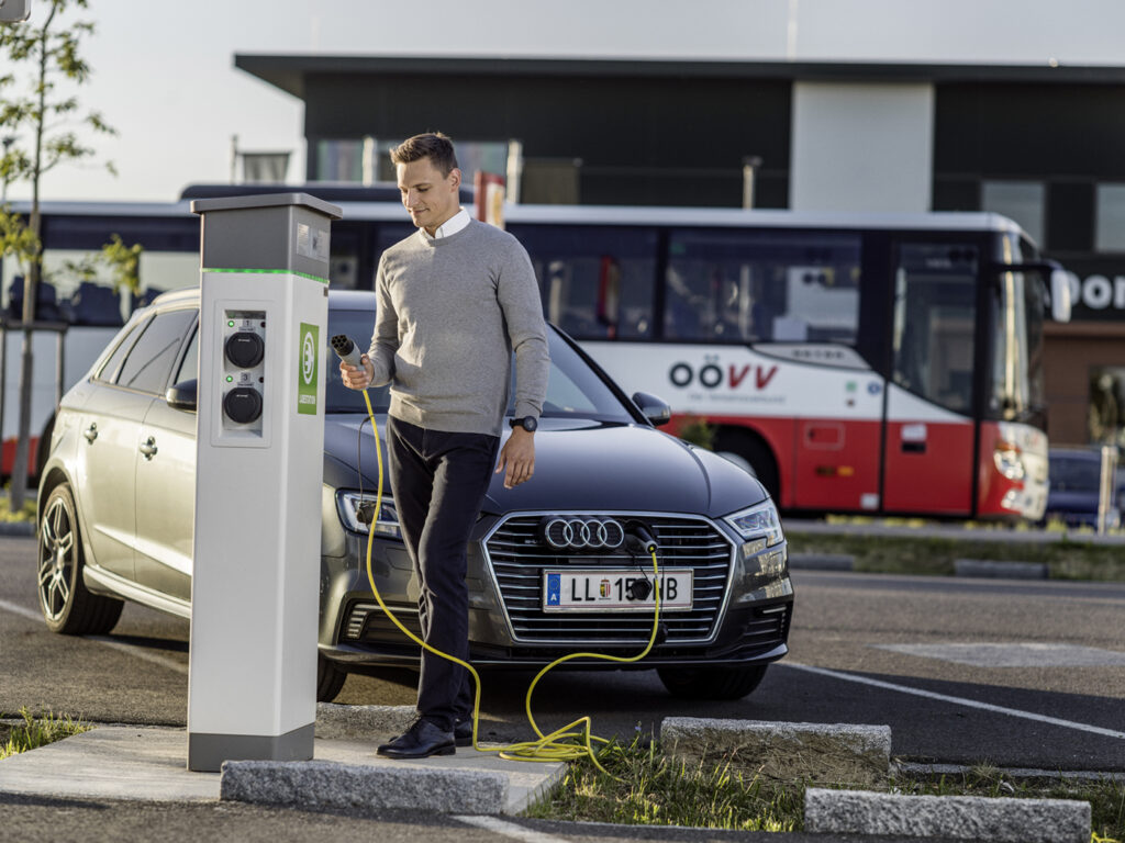 Mann nutzt E-Ladestation auf einer Park & Ride-Anlage