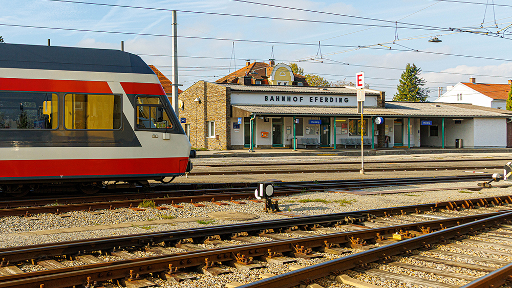 Blick auf den Bahnhof Eferding mit einem Fahrzeug der Linzer Lokalbahn im Vordergrund.