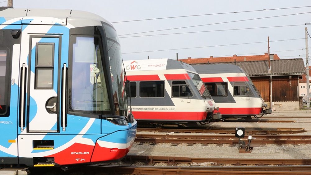 Seitlicher Blick auf ein TramTrain-Fahrzeug und ein Fahrzeug der Linzer Lokalbahn.