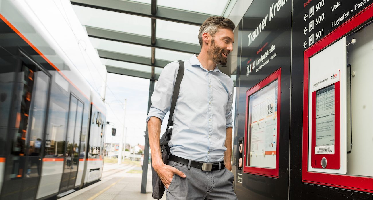 Mann informiert sich über den Fahrplan während die Straßenbahn abfährt