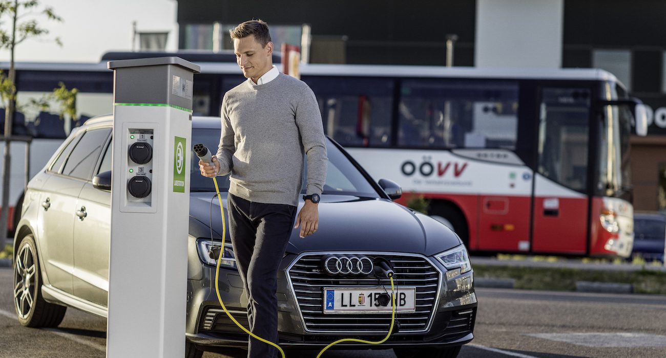 Mann nutzt E-Ladestation auf einer Park & Ride-Anlage