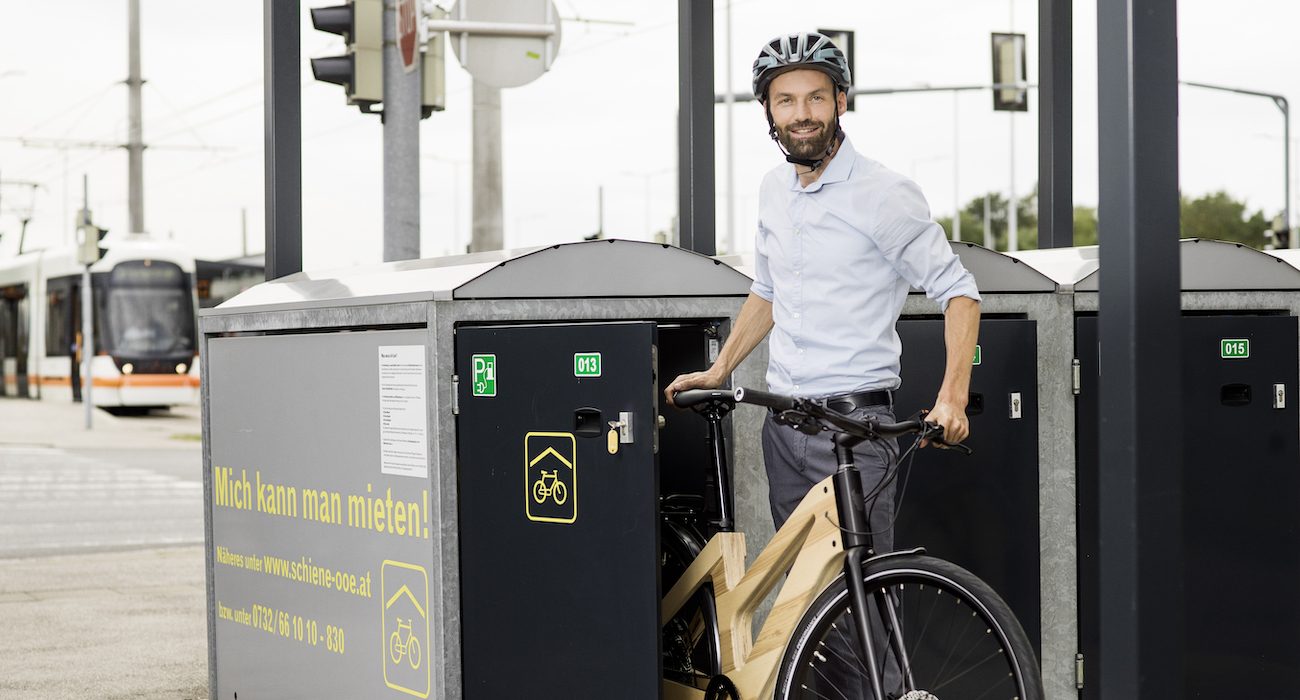 Mann schiebt Fahrrad aus Fahrradbox